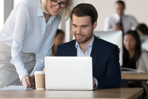 Gestora a orientar um novo franchisado no computador durante o processo de integração