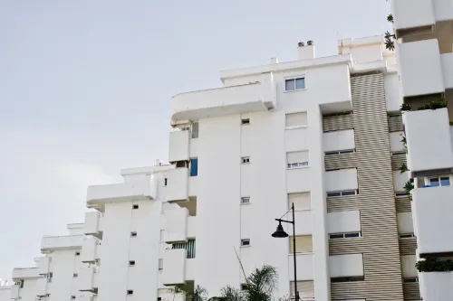 Edifício de apartamentos de cor branca com varandas, visto de baixo