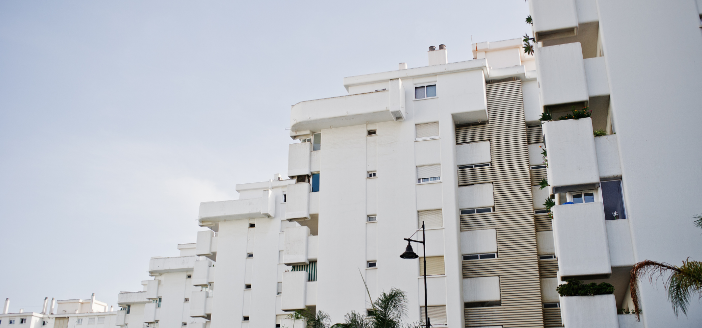 Edifício de apartamentos de cor branca com varandas, visto de baixo